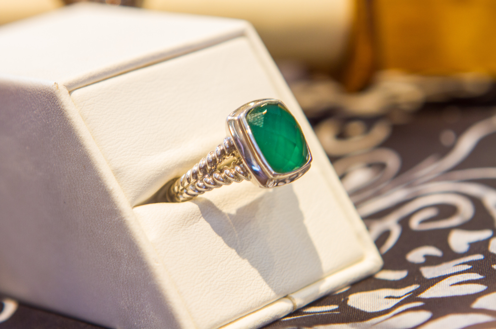 An emerald stone ring displayed in a box, a timeless piece of jewelry